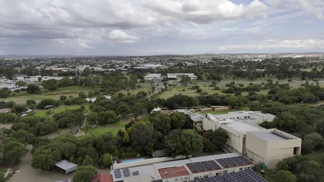 Drone orbits from back to front of Anglo-Boer War Museum in wide shot on cloudy afternoon in Bloemfontein, South Africa