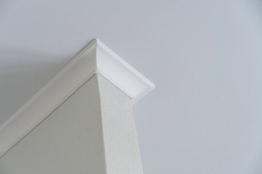 Interior corner with white crown molding and textured wall surface