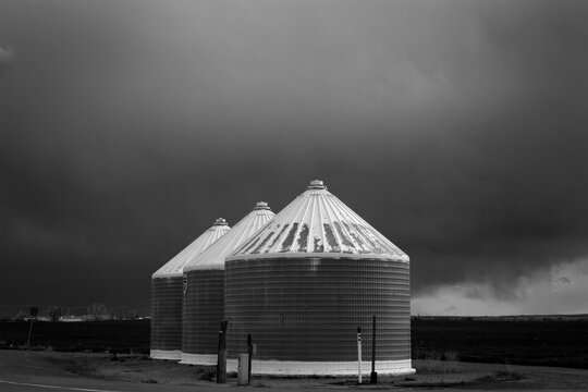 Grain Silos Under Storm Clouds Black and White Rural Agriculture Scene