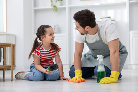 Spring cleaning. Father and daughter tidying up floor at home