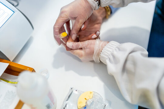 Pharmacist performing a blood test finger prick