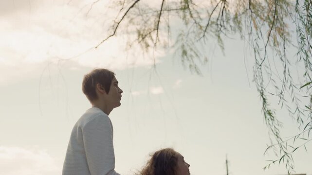 Family dreams unite. Sunlit embrace of hopeful family prospects. Silhouettes of parents with baby against bright backlight. Tender scene of parents and child with bright sun and promises