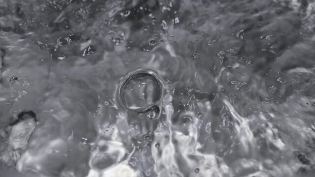 Close up of boiling water in a stainless steel pot in slow motion