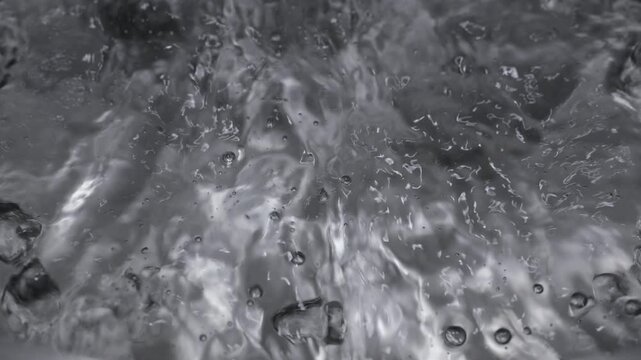 Close up of boiling water in a stainless steel pot in slow motion