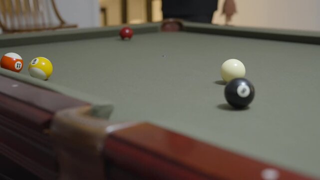 Close-up of a Man Playing Billiards and Pocketing a Ball