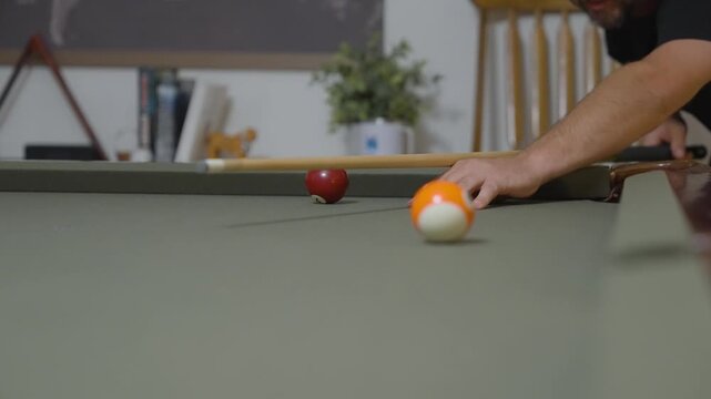 Close-up of a Man Playing Billiards and Pocketing a Ball