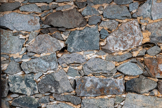 Different stones form a rough wall in a building