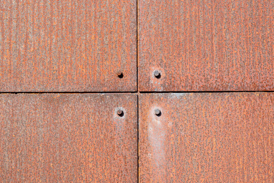 Rusty metal panels fit together in a grid pattern