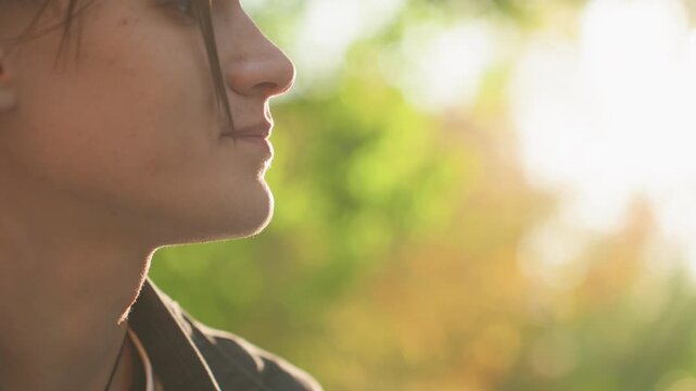 Sunlit white couple exchanging playful smiles outdoors, soft backlight and warm glow, closeup profiles and laughter, gentle gazes and affectionate touches capture joyful connection and hopeful