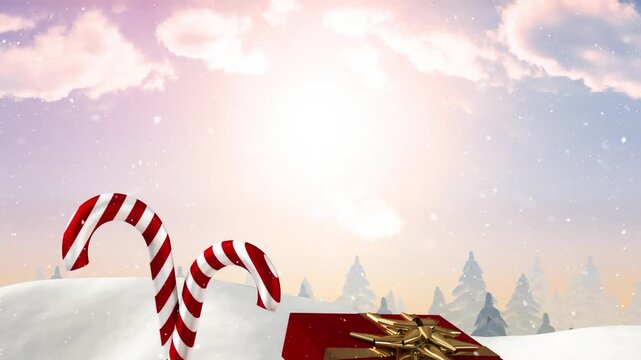 Animation of snow falling over christmas gift box and candy cane on winter landscape