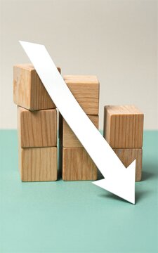 Wooden blocks with large white downward arrow symbolizing decline or