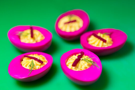 Bright pink deviled eggs with colorful presentation