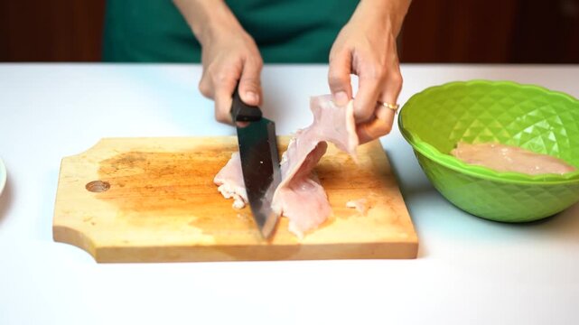 Close Up Slicing Raw Chicken Fillet on Cutting Board