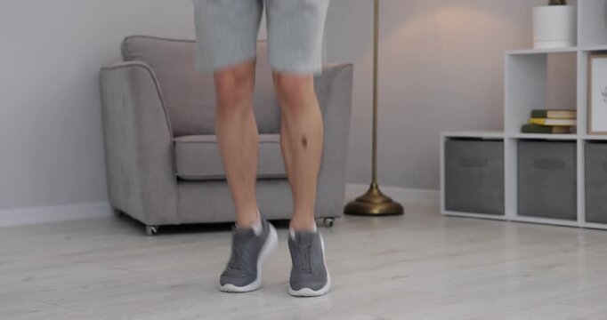 Man training with skipping rope indoors, closeup