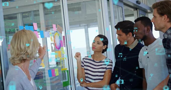 Animation of connected icons over diverse coworkers discussing strategy on sticky notes