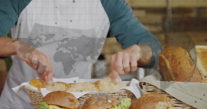 Male baker entering carrying bread basket onto countertop and arranging rolls for bakery display