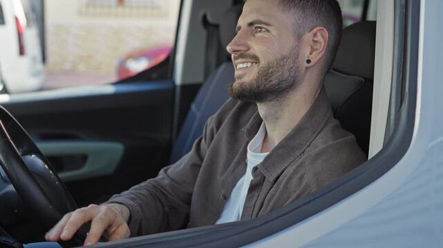 Man hispanic young smiling, right hand on steering wheel and left hand on gearshift inside parked car on street wearing casual shirt and smartwatch; calm confidence.