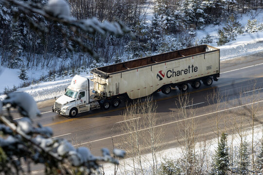 Canada, 22 January 2026 : Truck in snowy landscape, pine trees, winter road, transport, Charette logo