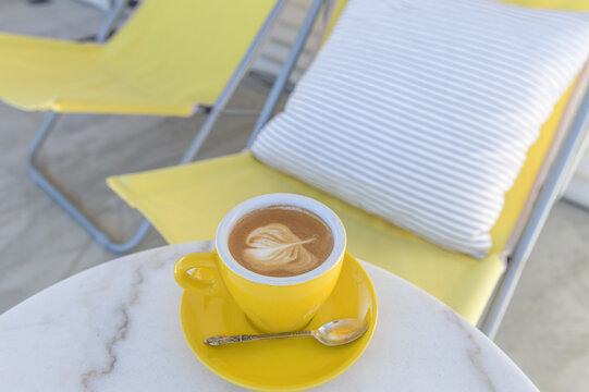 Yellow coffee cup and yellow outdoor sun chairs
