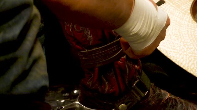 bull rider strapping up boots before event