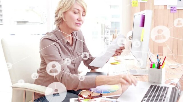Designer picking prints, checking screen, overlay spanning desk, annotating tablet for color check
