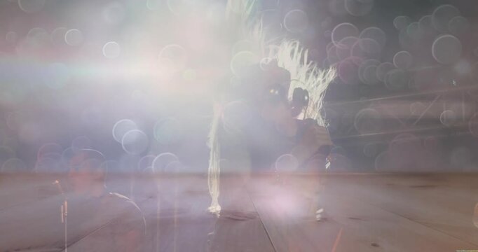 Light rising as female singer singing, flipping hair toward mic, bokeh hiding then showing halo