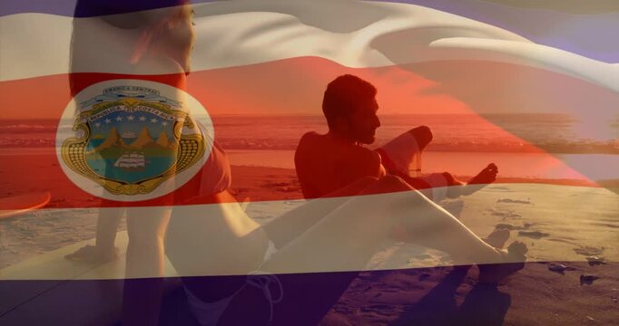 Vertical video: Waving flag, couple watching sunset, man checking phone on beach, bikini trunks
