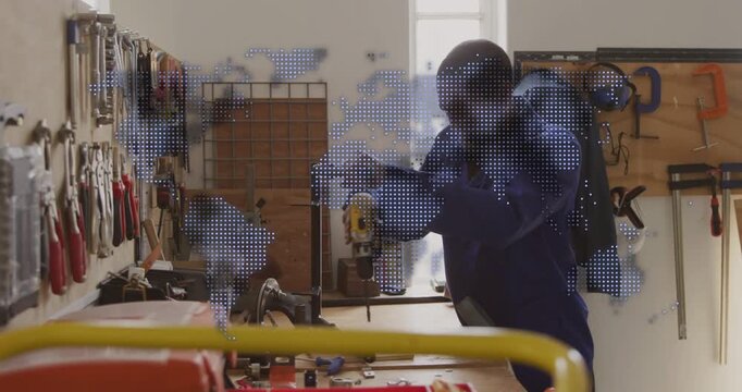 Man inspecting parts, picking yellow drill and fastening bracket for repair, dotted map animating