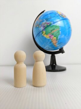 Wooden peg dolls and globe model symbolize global learning, cultural awareness, and educational exploration in a playful setting