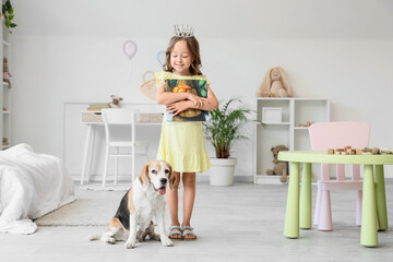 Obraz premium Cute little girl with Beagle dog and book in bedroom
