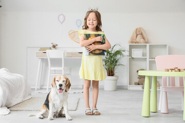 Obraz premium Cute little girl with Beagle dog and book in bedroom