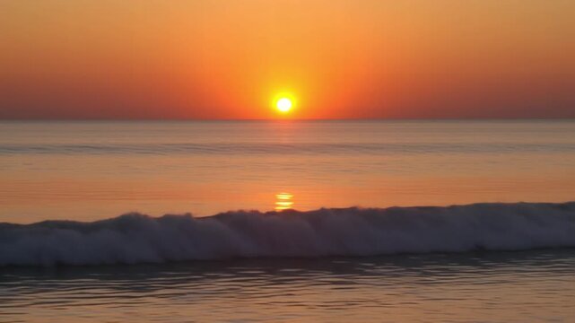 Breathtaking golden hour sun descending below the tranquil ocean horizon, casting shimmering reflections on the gentle, undulating waves as they slowly roll towards the shore during a beautiful time.