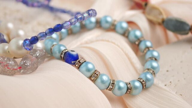 Close up view of pearl and bead necklaces on soft fabric, elegant jewelry accessories.