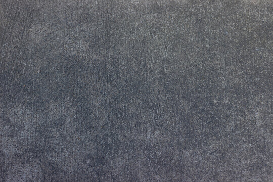 Gray concrete surface with uniform rough textured pattern creates neutral industrial background with minimalistic appearance