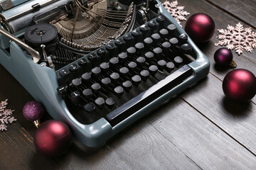 Obraz premium Vintage typewriter with Christmas balls and snowflakes on wooden background