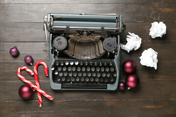 Obraz premium Vintage typewriter with Christmas balls and candy canes on wooden background