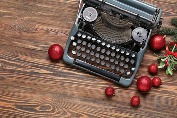 Obraz premium Vintage typewriter with Christmas balls, mistletoe and fir branches on wooden background