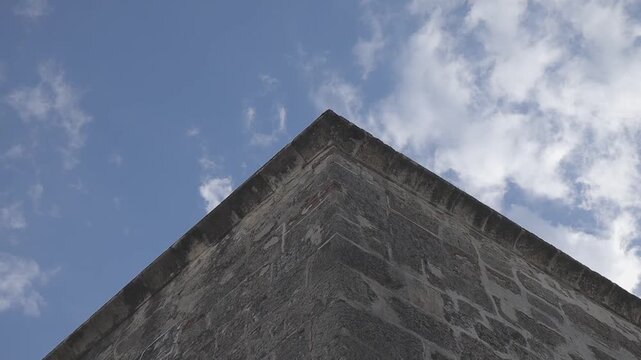 Low-angle shot of a building corner against a cloudy sky