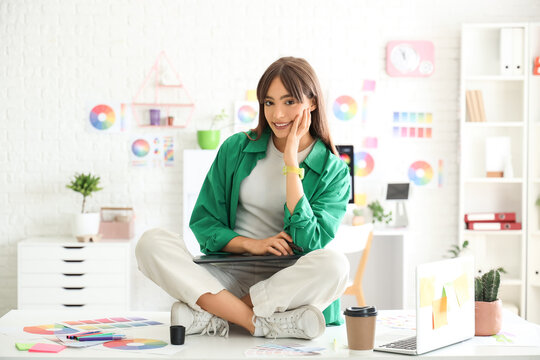 Graphic designer with tablet sitting on table in office