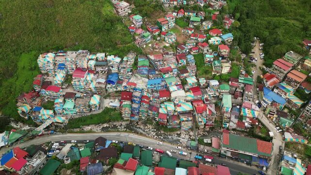 Scenic aerial drone shot of Valley of Colors, Baguio, Philippines - a mountainside, rural village with vibrant, colorful rooftops