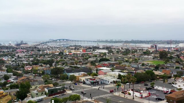 Drone flying toward the Coronado Bridge near downtown San Diego during early morning light with surrounding buildings visible