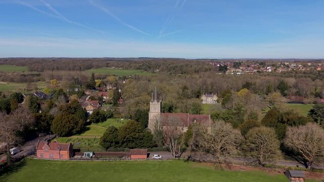 St Mary's Church, Hertingfordbury drone flight approaching the medieval parish church with stone tower and pitched nave roof, set among village homes and Hertfordshire countryside.