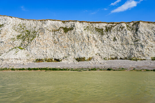 Towering white chalk cliffs and pebble beach at Cap Blanc-Nez on a sunny summer day, France