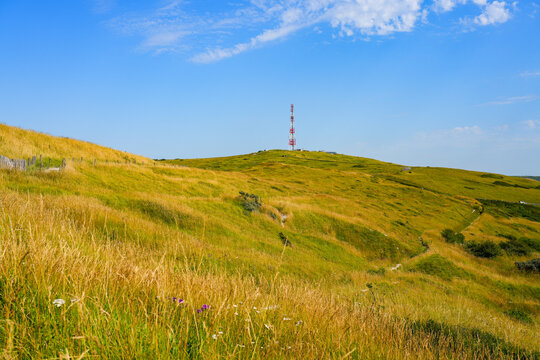 Grassy hills and communication tower under a blue summer sky at Cap Blanc-Nez on the Opal Coast, Pas-de-Calais, France