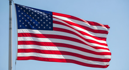 Obraz premium Full view of american flag attached to flagpole waving under clear blue sky on sunny day.
