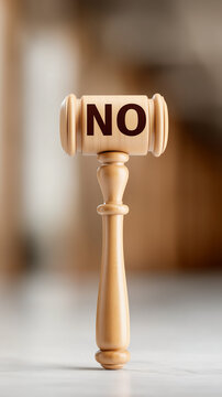 Symbol of Denial: A close-up shot of a wooden gavel prominently displays the word NO, symbolizing rejection, refusal, or a negative decision.