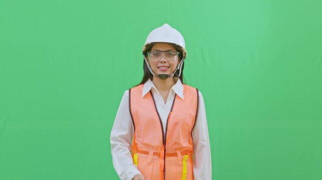 Female worker pointing at the blank chest area of her safety vest where a company logo would be. Perfect for corporate branding and identity videos.