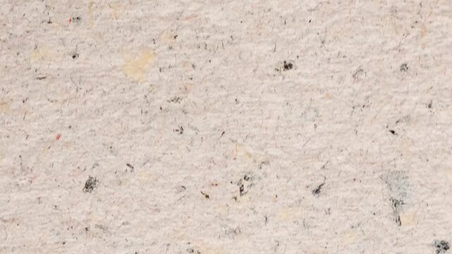 A close-up view of a speckled stone surface with small particles