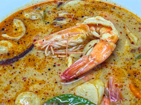 Thai Tom Yum Goong Soup with Large Prawn, Mushrooms, and Fragrant Herbs. Close Up Top View.