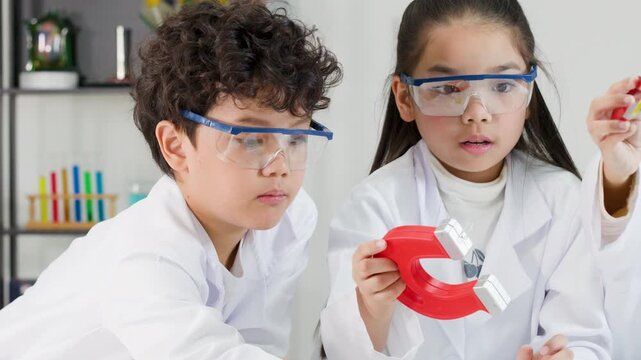 Asian Children in Lab Coats Experimenting with Horseshoe Magnets in Science Class